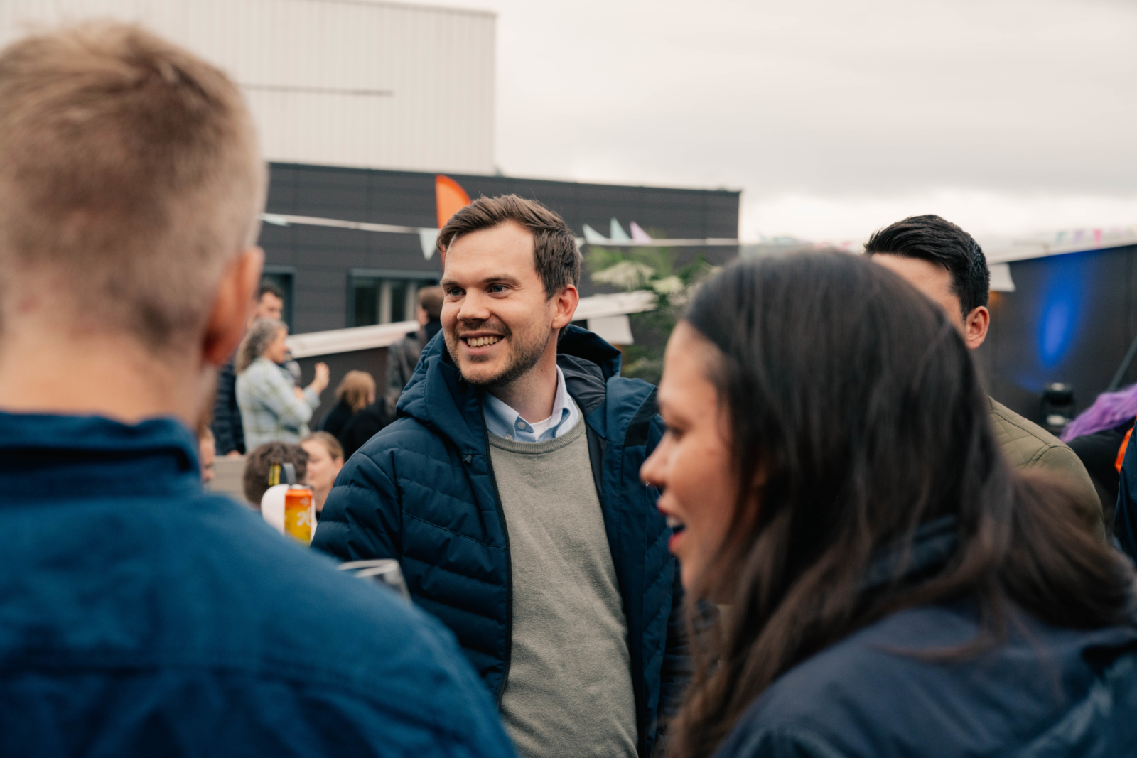 Ung smilende mann omringet av flere mennesker